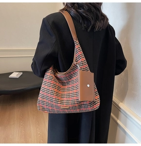 Detail of houndstooth fabric shoulder bag with leather strap and detachable mini pouch