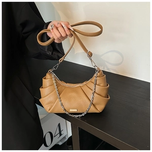 Close-up of caramel lychee leather crossbody bag with pleated design and silver chain