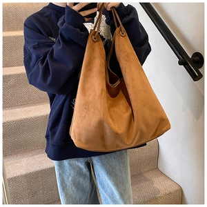 Détail du sac hobo en cuir givré camel avec fines anses rondes dans une scène intérieure