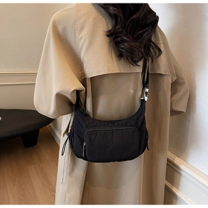 Modello con borsa a tracolla a mezzaluna in nylon nero con tracolla regolabile e tasca