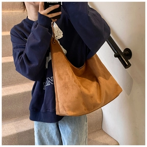 Gros plan du grand sac à bandoulière en daim caramel au design minimaliste et texture souple