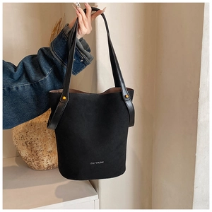 Détail du sac seau en PU noir mat avec des rivets dorés et une impression de logo blanc