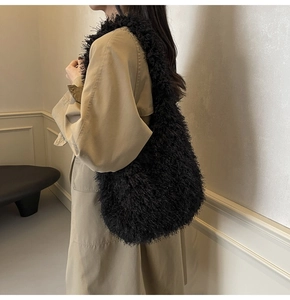 Gros plan du sac bandoulière en peluche noire porté par un mannequin en trench-coat