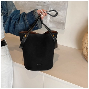 Détails de la surface en cuir PU mat et rivets dorés sur le sac seau noir