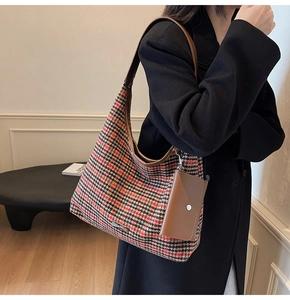 Detail of houndstooth tweed shoulder bag with leather strap and mini pouch attachment