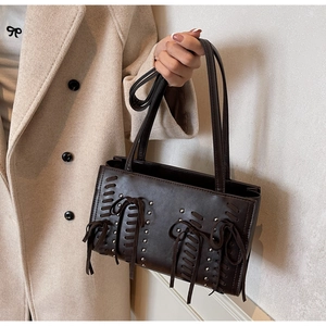 Detailed view of dark brown PU tote bag with woven straps and silver metal rivet accents