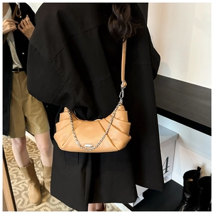 Detailed view of camel pleated crescent bag with textured leather and silver chain