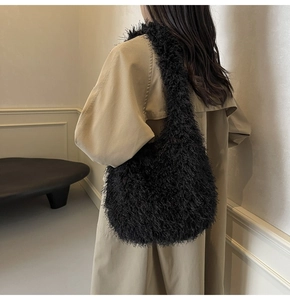 Détail du sac à épaule en fausse fourrure noire porté avec un trench-coat d'automne chic