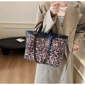 Détail du grand sac cabas à motif léopard avec lanières en cuir noir et rivets métalliques