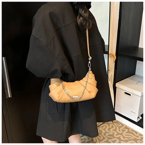Detail of the light khaki crescent handbag featuring elegant pleats and silver chain
