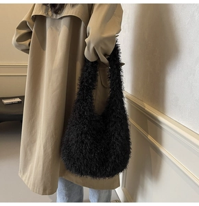 Grand sac cabas en fausse fourrure noire porté à l'épaule dans un décor minimaliste