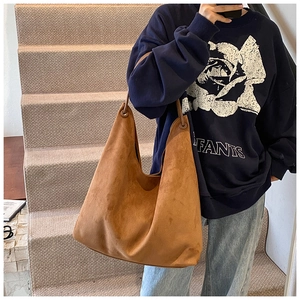 Vue détaillée du sac hobo en daim marron caramel avec anneau métallique sur la hanse