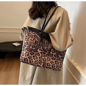 Détail du grand sac cabas imprimé léopard avec fines anses en cuir sur l'épaule