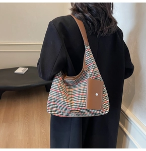 Detail of autumn houndstooth shoulder bag with brown leather strap and mini pouch