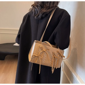 Detail of light khaki PU leather crossbody bag with woven texture and bow accents