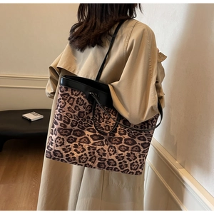 Grand sac cabas léopard avec lanières en cuir noir porté par un mannequin en studio