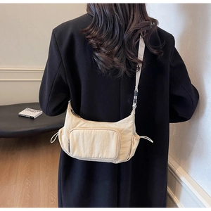 Dettaglio borsa a tracolla in nylon beige con tasche laterali e tracolla larga