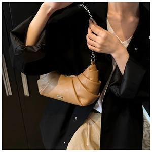 Detail of a brown PU leather crescent bag with side pleats and silver chain strap