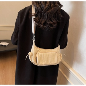 Vista dettagliata della borsa hobo in nylon crema con tasche a coulisse e tracolla regolabile