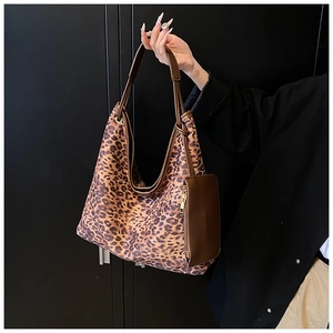 Détail du sac fourre-tout à imprimé léopard avec sangles en cuir et petite pochette