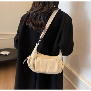 Dettaglio della borsa a tracolla in nylon beige con tracolla regolabile e coulisse