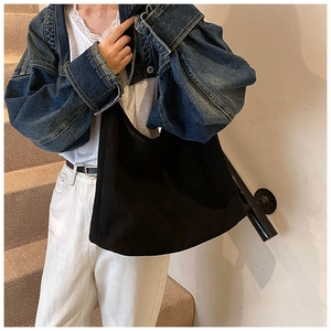 Détail d'un sac hobo noir minimaliste avec texture mate et grande capacité de rangement