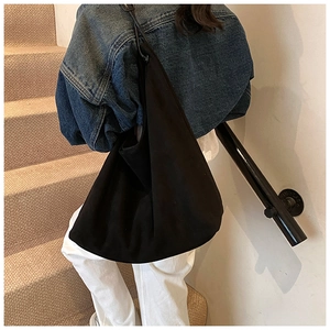 Sac hobo noir mat minimaliste porté par un mannequin montrant sa grande capacité