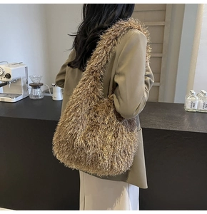 Vue détaillée de la texture à franges du grand sac cabas marron porté par un mannequin