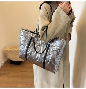 Détail du sac à bandoulière matelassé argenté avec surpiqûres et poignées noires
