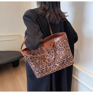 Détail d'un grand sac fourre-tout à motif léopard avec des anses en similicuir marron