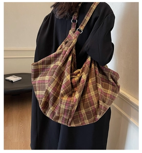 Détail d'un sac cabas à carreaux vintage avec anneaux en métal et tissu épais