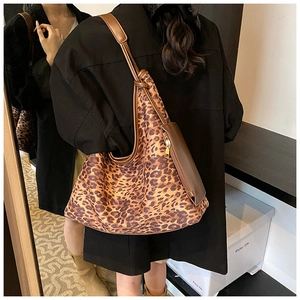 Détail du sac hobo léopard avec bordure en cuir marron et pochette zippée assortie incluse
