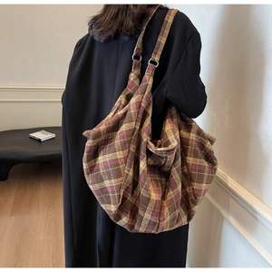 Détail du sac cabas vintage à carreaux avec anneau métallique sur la bandoulière