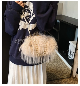 Detail of plush apricot shoulder bag featuring long faux fur fringe and pearl bow accents