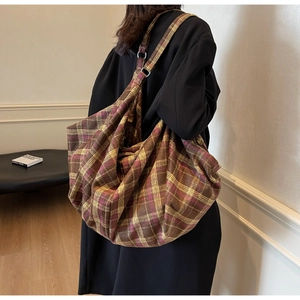 Détail du sac cabas en tissu souple avec motif à carreaux et anneaux métalliques