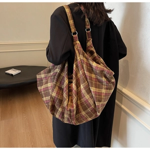 Vue détaillée du grand sac cabas en toile à carreaux jaune-brun avec anneaux en métal