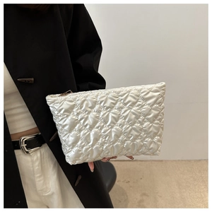 Gros plan détaillé d'une pochette blanche matelassée à motifs de cœurs et zip