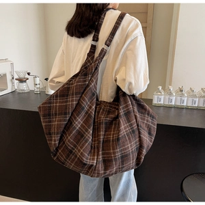 Détail d'un grand sac cabas vintage à carreaux marron avec anneaux métalliques