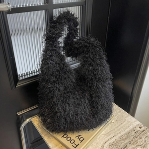 Sac à bandoulière chic en fausse fourrure noire avec texture pelucheuse sur décor épuré