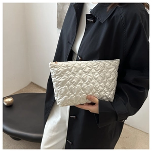 Détail du motif de cœur matelassé blanc et fermeture éclair sur une pochette élégante