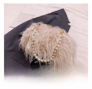 Detail shot of the plush faux fur texture with elegant pearl chain strap and gold clasp