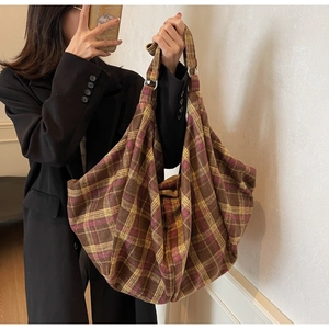 Vue détaillée du sac cabas à carreaux avec anneau argenté et tissu en laine souple