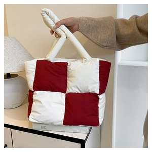 Macro shot of red and white checkered puffer tote bag with quilted padded texture