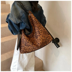 Détail du sac cabas léopard avec bandoulières en cuir noir et finitions dorées chic