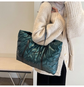 Grand sac cabas matelassé vert foncé avec fines anses noires porté par un mannequin