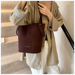 Détail d'un sac seau en cuir PU mat bordeaux avec poignée et lettrage embossé