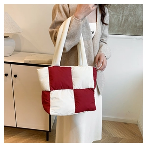 Detail of red and white checkered quilted puff tote bag with soft padded texture