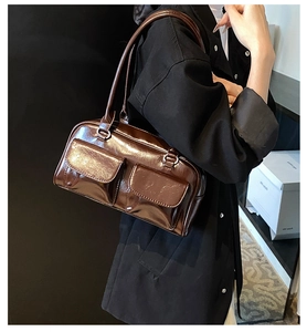 Close-up of a dark brown glossy PU leather shoulder bag with stylish dual front pockets