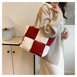 Detailed close-up of the red and white quilted nylon shoulder bag with a padded texture