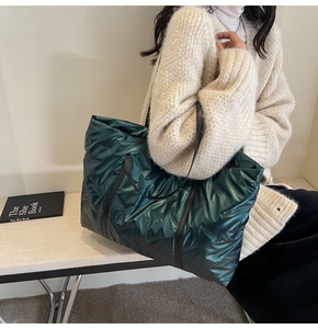 Sac fourre-tout matelassé vert foncé avec finition métallisée porté par un mannequin